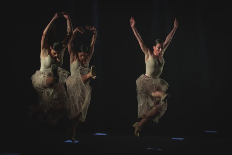 Mujeres bailando flamenco en el escenario fondo oscuro