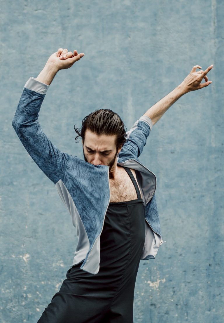 Hombre con camisa bailando flamenco con fondo de color verde