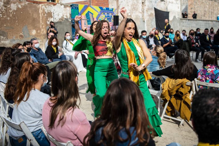 Mujeres bailando en la calle en medio de las personas