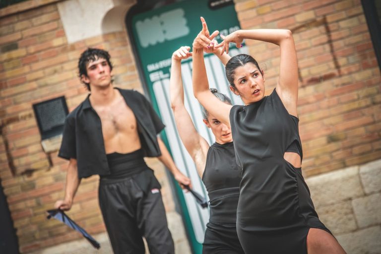 CHica vestida de negro bailando flamenco moderno en una presentación en la calle