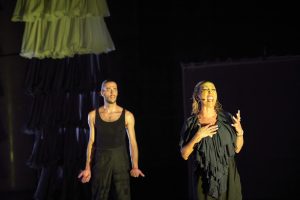 Hombre y mujer en escenario vestidos de negro